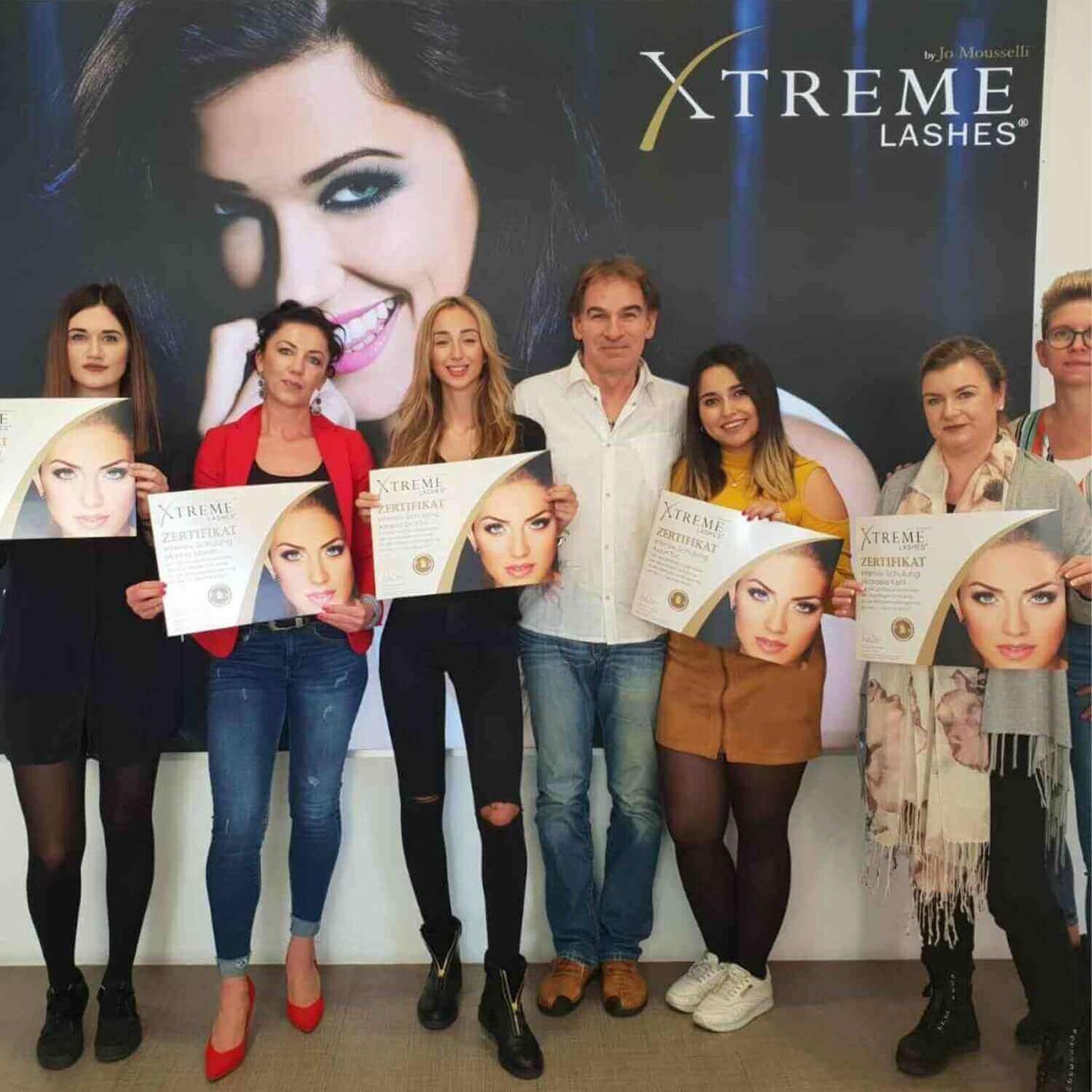 Wimpernverlängerungen Schulung Günter mit Schülern die Ihr Zertifikat zeigen nach der Master-Schulung in Düsseldorf