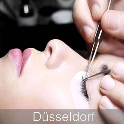 Ein Stylist arbeitet mit zwei Pinzetten am Augen und Aplliziert Wimpern